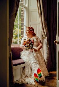 Plus size Katie on her wedding day, sat on a window seat