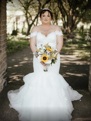 Curvy Kayleigh on her wedding day holding a bouque of flowerst
